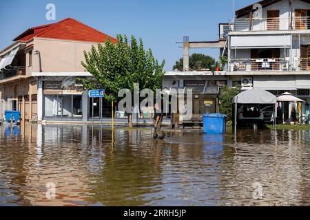 Karditsa, Griechenland. September 2023. Ein Mann geht über einen Platz im überfluteten Dorf Palamas, in der Nähe der Stadt Karditsa, Zentralgriechenland. Die Zahl der Todesopfer durch Überschwemmungen, die durch sintflutartige Regenfälle in Zentralgriechenland verursacht wurden, ist weiter gestiegen. Quelle: Yorgos Karahalis/dpa/Alamy Live News Stockfoto