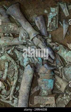 220616 -- GUANGHAN, 16. Juni 2022 -- Foto aufgenommen am 1. Juni 2022 zeigt verstreute Teile einer neu gefundenen Bronzeskulptur in der Opfergrube Nr. 8 der Sanxingdui Ruinen in der südwestlichen chinesischen Provinz Sichuan. Eine neu gefundene Bronzeskulptur an der berühmten Sanxingdui-Ruine wurde erfolgreich mit einem anderen Bronzewareteil verglichen, nachdem sie vor etwa 3.000 Jahren auseinandergenommen wurde, bestätigte das archäologische Team am Donnerstag. Die raffinierte Bronzeskulptur zeigt eine Figur eines menschlichen Kopfes und Schlangenkörpers mit hervorstehenden Augen, Stoßzähnen und Hörnern. Über dem Kopf befindet sich eine Zimttrompete Stockfoto