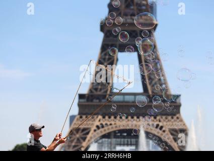 220616 -- PARIS, 16. Juni 2022 -- Ein Straßenkünstler macht Seifenblasen in der Nähe des Eiffelturms in Paris, Frankreich, am 16. Juni 2022. FRANCE-PARIS-EIFFELTURM-SOAP BUBBLES GAOXJING PUBLICATIONXNOTXINXCHN Stockfoto