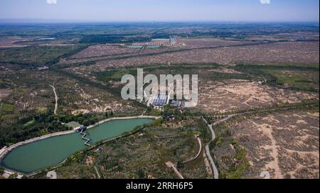 220617 -- YINCHUAN, 17. Juni 2022 -- Luftaufnahme aufgenommen am 15. Juni 2022 zeigt einen Blick auf das Baijitan National Ecological Reserve von Lingwu, nordwestchinesische Ningxia Hui Autonomous Region. Dank dreier Generationen engagierter Anstrengungen zur Sandkontrolle wurde eine 42 000 Hektar große Oase im Baijitan National Ecological Reserve von Lingwu am südwestlichen Rand der riesigen Maowusu-Wüste geschaffen. Die Oase ist inzwischen zu einer wichtigen Schutzbarriere für das ökologische System im Nordwesten Chinas geworden. Um die Wüste effektiv zu kontrollieren, haben sich die Einheimischen der Entwicklung profitabler Produkte verschrieben Stockfoto