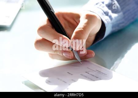 In der Nähe von eine Geschäftsfrau Hand Unterzeichnung prüfen Stockfoto