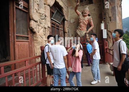 220618 -- TIANSHUI, 18. Juni 2022 -- Touristen besuchen die Maijishan Grotten in der Stadt Tianshui, nordwestchinesische Provinz Gansu, 9. Juni 2022. Die über 1.600 Jahre alten Maijishan-Grotten sind in den Höhlen eines isolierten Berggipfels an der alten Seidenstraße in der Stadt Tianshui gehauen. CHINA-GANSU-MAIJISHAN GROTTEN CN ChenxBin PUBLICATIONxNOTxINxCHN Stockfoto