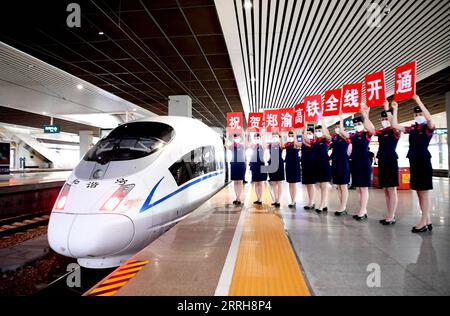 220620 -- ZHENGZHOU, 20. Juni 2022 -- Zugbegleiter feiern neben dem Zug G3401 im Ostbahnhof Zhengzhou in Zhengzhou, Provinz Henan in Zentralchina, 20. Juni 2022. Mit einer Gesamtlänge von 1.068 km nahm die Zhengzhou-Chongqing High-Speed Railway am Montag ihren Betrieb auf. Durch die Linie kann die Reisezeit von Chongqing nach Zhengzhou von etwa 8 Stunden auf 4 Stunden 23 Minuten bei Höchstgeschwindigkeit verkürzt werden, während die kürzeste Zeit von Chongqing nach Peking von mehr als 20 Stunden auf weniger als 7 Stunden verkürzt wird. CHINA-CHONGQING-ZHENGZHOU-RAILWAY-FULL OPERATION CN HAOXYUAN PUBLIC Stockfoto