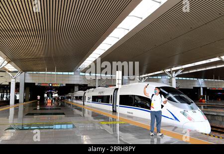 220620 -- ZHENGZHOU, 20. Juni 2022 -- Ein Passagier posiert für ein Selfie-Foto vor dem Zug G3401 in Zhengzhou East Railway Station in Zhengzhou, zentralchinesische Provinz Henan, 20. Juni 2022. Mit einer Gesamtlänge von 1.068 km nahm die Zhengzhou-Chongqing High-Speed Railway am Montag ihren Betrieb auf. Durch die Linie kann die Reisezeit von Chongqing nach Zhengzhou von etwa 8 Stunden auf 4 Stunden 23 Minuten bei Höchstgeschwindigkeit verkürzt werden, während die kürzeste Zeit von Chongqing nach Peking von mehr als 20 Stunden auf weniger als 7 Stunden verkürzt wird. CHINA-CHONGQING-ZHENGZHOU-EISENBAHNBETRIEB Stockfoto