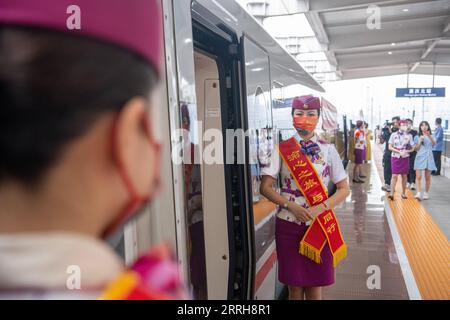 220620 -- CHONGQING, 20. Juni 2022 -- Zugbegleiter G52 warten auf Passagiere in der südwestchinesischen Gemeinde Chongqing, 20. Juni 2022. Mit einer Gesamtlänge von 1.068 km nahm die Zhengzhou-Chongqing High-Speed Railway am Montag ihren Betrieb auf. Durch die Linie kann die Reisezeit von Chongqing nach Zhengzhou von etwa 8 Stunden auf 4 Stunden 23 Minuten bei Höchstgeschwindigkeit verkürzt werden, während die kürzeste Zeit von Chongqing nach Peking von mehr als 20 Stunden auf weniger als 7 Stunden verkürzt wird. CHINA-CHONGQING-ZHENGZHOU-RAILWAY-FULL OPERATION CN TANGXYI PUBLICATIONXNOTXINXCHN Stockfoto