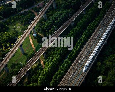 220620 -- WUHAN, 20. Juni 2022 -- Luftbild zeigt einen Hochgeschwindigkeitszug, der auf dem Abschnitt Peking-Wuhan der Peking-Guangzhou Hochgeschwindigkeitsbahn in Wuhan, der zentralchinesischen Provinz Hubei, fährt, 20. Juni 2022. Eine Hochgeschwindigkeitsbahn, die Peking mit Wuhan, der Hauptstadt der zentralchinesischen Provinz Hubei, verbindet, nimmt am Montag mit einer Geschwindigkeit von 350 km/h den normalen Betrieb auf, sagte die China State Railway Group Co., Ltd Mit einer Erhöhung der Zuggeschwindigkeit von 310 km/h auf 350 km/h wird die Gesamtkapazität des Abschnitts voraussichtlich um 7 Prozent steigen, und die kürzeste Strecke zwischen Peking und Wuhan hat b Stockfoto