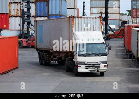 Gütertransporter, Containerkästen im logistischen Reederei mit Stapeln von Frachtcontainern im Hintergrund. Stockfoto