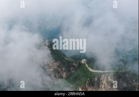 220704 -- PEKING, 4. Juli 2022 -- Luftaufnahme vom 4. Juli 2022 zeigt Wolken, die über der Chinesischen Mauer im Grenzgebiet zwischen dem Luanping County in der nordchinesischen Provinz Hebei und dem Bezirk Miyun in Peking, der Hauptstadt Chinas, schweben. CHINA-PEKING-GREAT WALL-LANDSCHAFT CN CHENXYEHUA PUBLICATIONXNOTXINXCHN Stockfoto