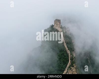 220704 -- PEKING, 4. Juli 2022 -- Luftaufnahme vom 4. Juli 2022 zeigt Wolken, die über der Chinesischen Mauer im Grenzgebiet zwischen dem Luanping County in der nordchinesischen Provinz Hebei und dem Bezirk Miyun in Peking, der Hauptstadt Chinas, schweben. CHINA-PEKING-GREAT WALL-LANDSCHAFT CN CHENXYEHUA PUBLICATIONXNOTXINXCHN Stockfoto