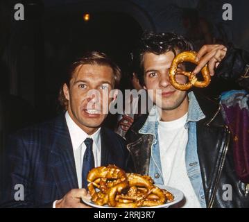 Michael Lesch, deutscher Schauspieler (links) und Kollege Marek Erhardt mit Laugenbrezeln auf dem Weihnachtsmarkt, Deutschland um 1991. Stockfoto