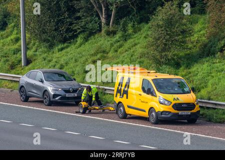 24-Stunden-Pannenhilfe von einem gelben AA-Transporter, da der Autofahrer einen Motorschaden erleidet, ein defektes Fahrzeug, das auf der Autobahn in Manchester, Großbritannien, geparkt ist Stockfoto