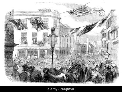 Feierlichkeiten in Jersey zur Eröffnung des Channel Islands Telegraph, 1858. Blick auf "...die Szene der beliebten Aufregung zu diesem Anlass in den Straßen von St. Helier. Dienstag, der 7. September war wirklich ein großartiger Tag für Jersey. denn an diesem Tag wurde die Kommunikation durch die elektrische U-Boot-Linie zwischen dieser Insel und Großbritannien eröffnet... die Straßen waren voll von Menschen... Eine Prozession, begleitet von Militärbands, die durch die Stadt zogen... die Glocken der Stadtkirchen wurden geläutet, und die feine Band der Royal Artillery... schlug auf "Gott rette die Königin!"... die bürgerliche und andere au Stockfoto