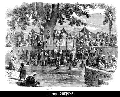 A Hindoo Fair in Cashmere, 1858. Baden in Indien. "Im Sommer sind die Bewohner von Kaschmir sehr süchtig nach Pilgerfahrten zu den verschiedenen Orten, die die Tradition als heilig bezeichnet hat, und das Hauptmerkmal am heiligen Ort ist immer ein Frühling, oft von beträchtlichem Volumen, das Wasser ist in einem Tank eingeschlossen. die Menschen hier verrichten ihre Verehrung unter der Aufsicht der Brahmanen, bringen Opfer und erhalten dafür das heilige Zeichen auf ihrer Stirn. Das Baden im Tank geht den ganzen Tag weiter... Kabinen werden um den Tank herum aufgestellt, wo Provisio ist Stockfoto