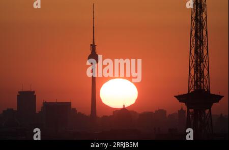 Berlin, Deutschland. September 2023. Die Sonne geht zwischen dem Funkturm und dem Fernsehturm über Berlin auf. Quelle: Ralf Hirschberger/dpa/Alamy Live News Stockfoto
