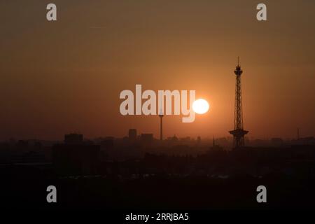 Berlin, Deutschland. September 2023. Die Sonne geht zwischen dem Funkturm und dem Fernsehturm über Berlin auf. Quelle: Ralf Hirschberger/dpa/Alamy Live News Stockfoto