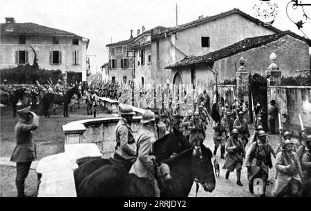 "Ankunft französischer Truppen in Italien; beim Betreten des Dorfes, in dem sie stationiert sind, marschiert ein französisches Regiment an seinem Oberst vorbei", 1917. Aus L’Album de la Guerre 1914-1919, Band 2 [L’Illustration, Paris, 1924]. Stockfoto