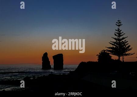 Die letzten Sonnenstrahlen prägen die gewaltigen Meeresstapel, während die Dämmerung über Ponta dos Mosteiros in Sao Miguel, Azoren, Portugal, abfällt. Stockfoto