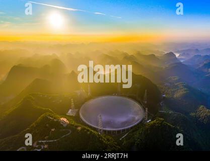 220806 -- GUIZHOU, 6. Aug. 2022 -- Luftaufnahme aufgenommen am 25. Juli 2022 zeigt Chinas fünfhundert Meter Aperture Spherical Radio Telescope, das bei Sonnenaufgang in der Provinz Guizhou im Südwesten Chinas SCHNELL gewartet wird. FAST befindet sich in einer natürlichen tiefen und runden Karstdepression in der südwestlichen chinesischen Provinz Guizhou und begann im Januar 2020 seine offizielle Operation und wurde am 31. März 2021 offiziell für die Welt eröffnet. Es gilt als das empfindlichste Radioteleskop der Welt. Mit FAST haben Wissenschaftler über 660 neue Pulsare identifiziert. EYESONSCI CHINA-GUIZHOU-ASTRONOMIE-SCHNELLTELESKOP CN OUXDONGQU PUBLIC Stockfoto