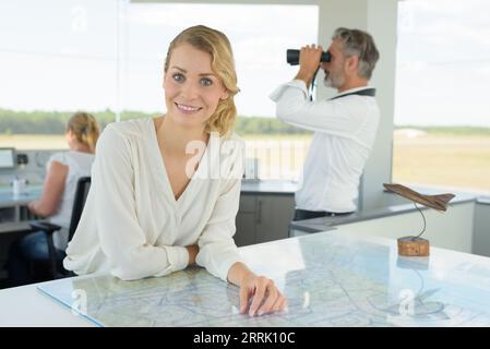 Eine glückliche Frau kontrolliert die Flugplätze Stockfoto