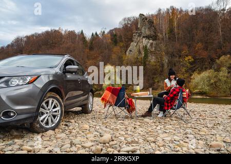 Pärchen picknicken am Herbstfluss Stockfoto