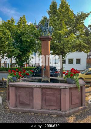 Amöneburg, Hessen, Deutschland - Brunnen am Marktplatz in der Altstadt. Amöneburg ist eine Kleinstadt im mittelhessischen Stadtteil Marburg-Biedenkopf. Sie liegt auf dem 365 m hohen Amöneburg mit der Burg Amöneburg an der Spitze. Stockfoto