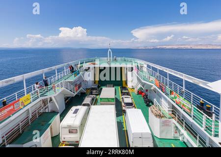 Kroatien, Kvarner Bucht, Adriaküste, Fähre von Lopar (Insel Rab) nach Valbiska (Insel Krk), Blick von der Fähre mit geparkten Autos und Passagieren an Deck Stockfoto