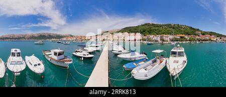 Kroatien, Primorje-Gorski Komitat Kotar, Insel Krk, kleine Boote im Jachthafen von Baska, im Hintergrund die Häuser zum Ufer Stockfoto
