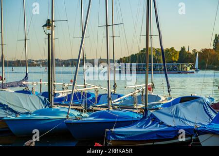 Hamburg, Steg mit Segelbooten auf der Aussenalster im Vordergrund, Nahaufnahme, Ausflugsboot im Hintergrund Stockfoto