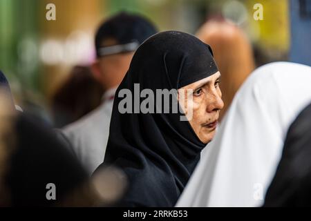 Eine ältere Frau mit grauem Haar, die Abayas trägt und die Kamera anlächelt Stockfoto