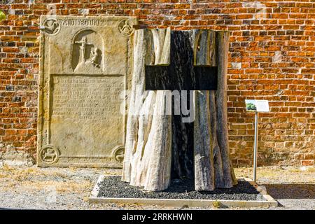 Kreuzschnitt aus Hohlbaumstamm, im Hintergrund Epitaph von 1580 aus der Vorgängerkirche Stockfoto