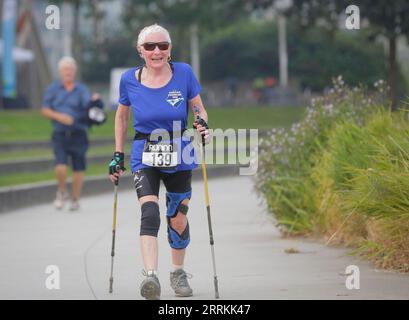 220912 -- RICHMOND, 12. September 2022 -- ein älterer Teilnehmer geht mit Trekkingstöcken während des Forever Young 8K Laufs in Richmond, British Columbia, Kanada, am 11. September 2022. Hunderte von Seniorläufern, Joggern und Spaziergängern nahmen am Sonntag am jährlichen Forever Young 8K Run Teil. Die Veranstaltung kehrte zum achten Mal zurück, nur für Menschen ab 55 Jahren, mit dem Ziel, ein aktives und gesundes Seniorenleben zu fördern. Foto von /Xinhua CANADA-RICHMOND-ELDERS-RUNNING LiangxSen PUBLICATIONxNOTxINxCHN Stockfoto