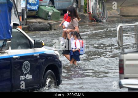 220913 -- BANGKOK, 13. September 2022 -- Menschen waten am 13. September 2022 in Bangkok, Thailand durch das Hochwasser. Die Bangkok Metropolitan Administration BMA gab am Dienstag eine Warnung vor mittelschweren bis schweren Regenfällen und möglichen Überschwemmungen von 16:00 bis 23:00 Uhr Ortszeit in den 12 Bezirken der thailändischen Hauptstadt heraus. Dies geschah, nachdem mehrere Teile der Stadt nach schweren Monsunregen in den letzten Tagen überflutet worden waren. THAILAND-BANGKOK-FLOODS RachenxSageamsak PUBLICATIONxNOTxINxCHN Stockfoto