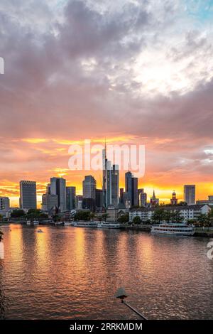 Sonnenuntergang über der Frankfurter Skyline, Blick über den Main zur Bankenstadt mit Wolkenkratzern am Abend Stockfoto