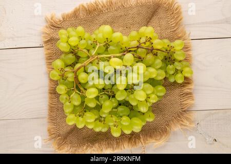 Süße Bio-Trauben mit Jute Serviette auf Holztisch, Makro, Blick von oben. Stockfoto