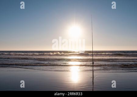 Angeln am Sandstrand am Meer Stockfoto