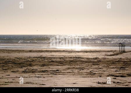 Fußballtor am Sandstrand am Meer Stockfoto