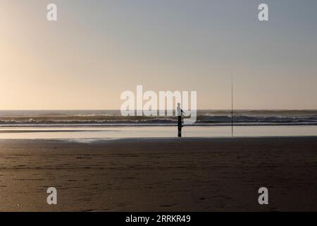 Angeln am Sandstrand am Meer Stockfoto