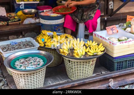 Verkauf von Lebensmitteln auf Schienen, Maeklong Railway Market, Talad Rom Hub Railway Market, in der Nähe von Bangkok, Samut Songkhram, Thailand, Asien. Stockfoto