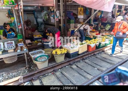 Verkauf von Lebensmitteln auf Schienen, Maeklong Railway Market, Talad Rom Hub Railway Market, in der Nähe von Bangkok, Samut Songkhram, Thailand, Asien. Stockfoto