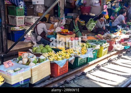 Verkauf von Lebensmitteln auf Schienen, Maeklong Railway Market, Talad Rom Hub Railway Market, in der Nähe von Bangkok, Samut Songkhram, Thailand, Asien. Stockfoto