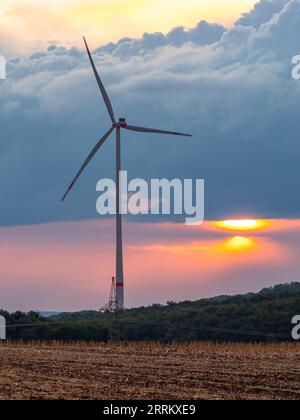 Windturbinen in Thüringen mit abfahrendem Gewitter im Sonnenuntergang. Stockfoto