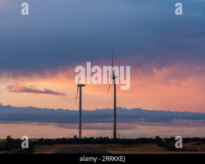 Windturbinen in Thüringen mit abfahrendem Gewitter im Sonnenuntergang. Stockfoto