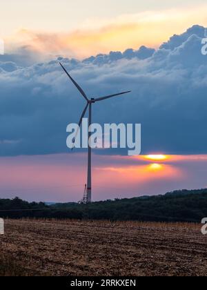 Windturbinen in Thüringen mit abfahrendem Gewitter im Sonnenuntergang. Stockfoto