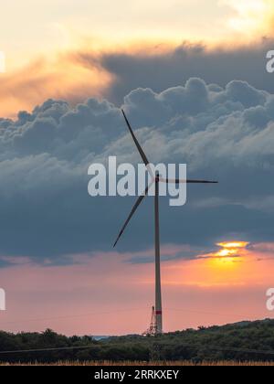 Windturbinen in Thüringen mit abfahrendem Gewitter im Sonnenuntergang. Stockfoto