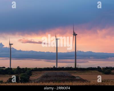 Windturbinen in Thüringen mit abfahrendem Gewitter im Sonnenuntergang. Stockfoto