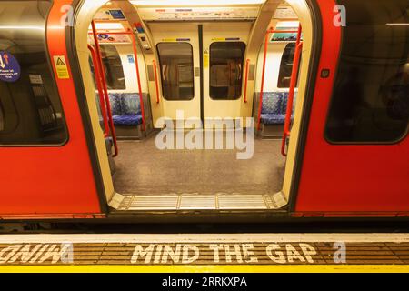 England, London, London U-Bahn, stationärer Zug mit Mind the Gap Schild Stockfoto