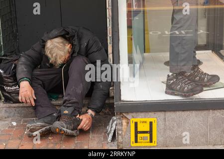 England, Sussex, East Sussex, Eastbourne, Obdachloser Mann in Tür und Schaufenster Stockfoto