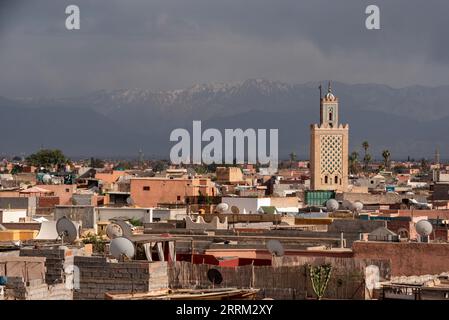 Malerischer Blick auf die Medina von Marrakesch und das Atlasgebirge im Hintergrund bei stürmischem Wetter, Marokko Stockfoto