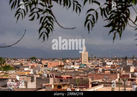 Malerischer Blick auf die Medina von Marrakesch und das Atlasgebirge im Hintergrund bei stürmischem Wetter, Marokko Stockfoto