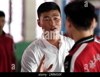 220929 -- ZHENGZHOU, 29. September 2022 -- Li Yinggang L unterrichtet Schüler während eines Kampfkunstkurses an der Shaolin Tagou Martial Arts School in Songshan, Provinz Henan in Zentralchina, 6. Juli 2022. Der 25-jährige Li Yinggang ist Coach an der Shaolin Tagou Martial Arts School in Songshan, der zentralchinesischen Provinz Henan. Im Alter von 9 Jahren begann er mit dem Kampfsport und wechselte drei Jahre später in den freien Kampf. Seit er 16 Jahre alt war, nimmt Li an den professionellen Freikampfwettbewerben Teil und gewann mehrmals die Titel nationaler und internationaler Veranstaltungen, darunter zwei goldene Bels Stockfoto